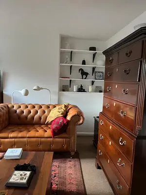 a living room with a brown couch and a dresser at Deal - The place to stay in Moffat