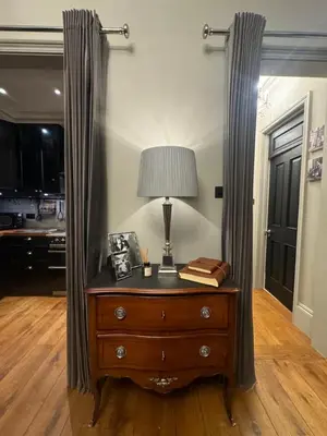 a table with a lamp on top of a dresser at West London Boutique Apartment in Moffat