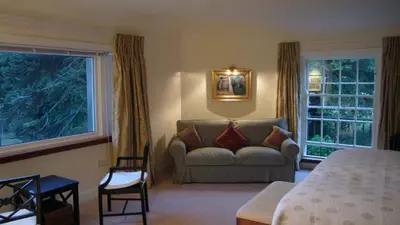 a bedroom with a bed and a couch and a window at Melfort House in Kilmelford