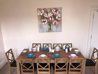 a dining room table with chairs and a painting on the wall at Edinburgh Central Morrison Roomz in Edinburgh