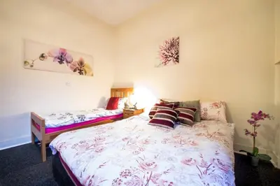 a bedroom with a large bed with pillows on it at Edinburgh Central Morrison Roomz in Edinburgh