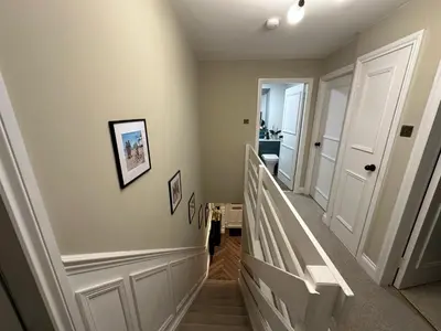 a staircase in a home with a hallway with white walls at Riverview House in Minnigaff