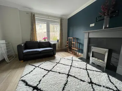 a living room with a couch and a fireplace at ShekNup Home in Edinburgh
