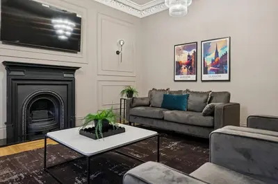 a living room with a couch and a fireplace at Spacious 5 Bedroom Home With 3 Bathrooms And Private Parking in Glasgow