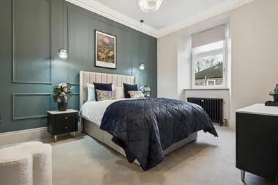 a bedroom with a bed and a green wall at Spacious 5 Bedroom Home With 3 Bathrooms And Private Parking in Glasgow