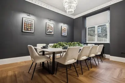 a dining room with a table and chairs at Spacious 5 Bedroom Home With 3 Bathrooms And Private Parking in Glasgow