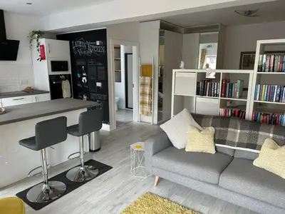 a living room with a couch and a bar in it at The Studio in Dunfermline