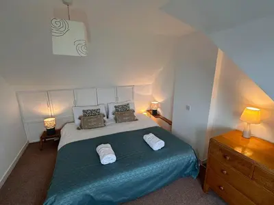 a bedroom with a bed with two pillows on it at Curlew Cottage - Peaceful Setting Stunning Views in Bruichladdich