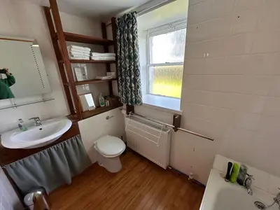 a bathroom with a sink and a toilet and a window at Curlew Cottage - Peaceful Setting Stunning Views in Bruichladdich