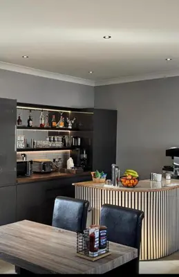 a kitchen with a table and chairs and a counter at Belstane Manor in Carluke