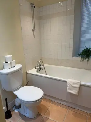 a bathroom with a toilet and a tub and a sink at Stylish Glasgow Apartment in Whiteinch
