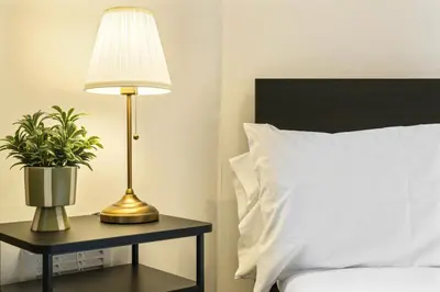 a lamp on a table next to a bed with a pillow at City-Close 1-Bedroom Apartment - Edinburgh in Edinburgh