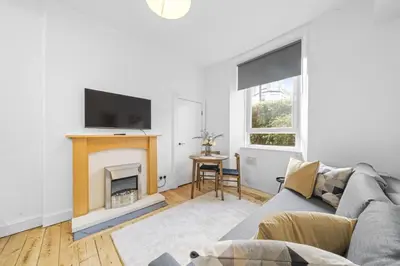 a living room with a couch and a fireplace at City-Close 1-Bedroom Apartment - Edinburgh in Edinburgh