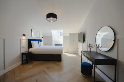 a bedroom with a bed and a mirror and a desk at Old Church Apartment 4 in Oban