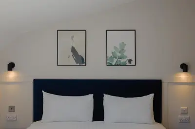 a bedroom with a bed with two pictures on the wall at Old Church Apartment 5 in Oban