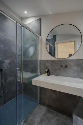 a bathroom with a shower and a sink and a mirror at Old Church Apartment 5 in Oban