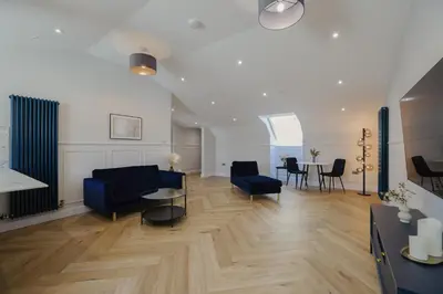 a living room with a blue couch and a table at Old Church Apartment 5 in Oban