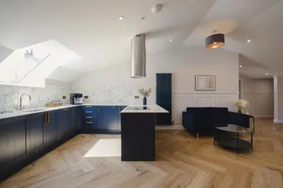 a kitchen with blue cabinets and a table in a room at Old Church Apartment 5 in Oban
