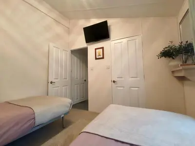 a bedroom with two beds and a flat screen tv at 10 lochview in Moffat