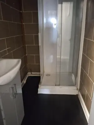 a shower with a glass door in a bathroom at Akwaaba services in Moffat