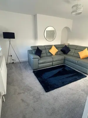 a living room with a couch and a mirror at Plains Town House, Airdrie in Caldercruix