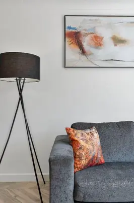 a living room with a couch and a lamp at Stylish 4Bed Home Free Parking 20 Min to Edinburgh in Livingston