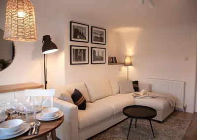 a living room with a white couch and a table at Justina's House in East Kilbride