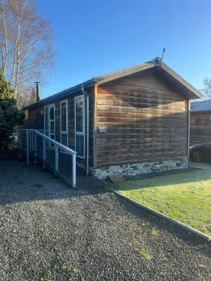 a log cabin with a porch on a yard at The Eden, Cosy 1 bed lodge with riverside views in Crieff