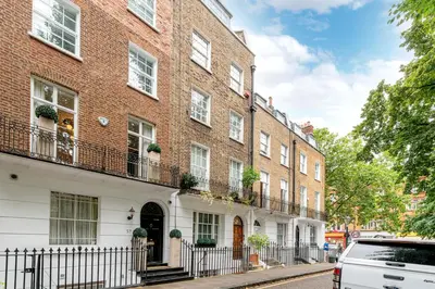 a large brick building with windows and balconies on a street at Knightsbridge Duplex Two Bedroom Apartment in Moffat