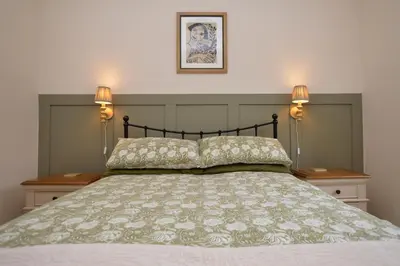 a bedroom with a bed with two lamps on it at Seascape in Kames