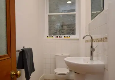 a bathroom with a sink and a toilet and a window at Secret Coast Getaway in Tighnabruaich
