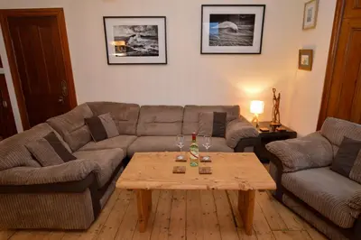 a living room with a couch and a coffee table at Secret Coast Getaway in Tighnabruaich