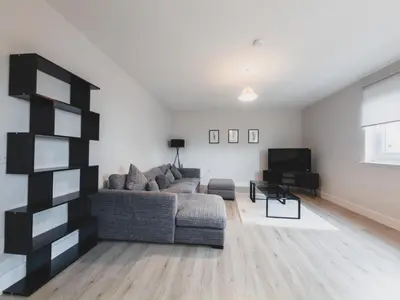 a living room with a couch and a television at Finnieston Apartment in Glasgow