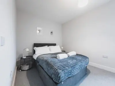 a bedroom with a bed with two pillows on it at Finnieston Apartment in Glasgow