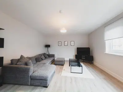 a living room with a couch and a television at Finnieston Apartment in Glasgow