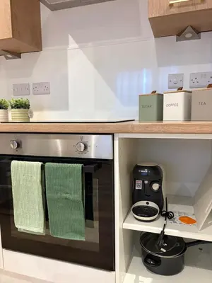 a kitchen with a stove with two green towels at 7 min from Edinburgh Airport 2 Bedroom Apartment in Edinburgh