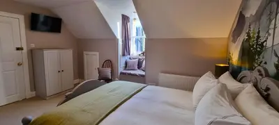 a bedroom with a large white bed in a room at Craigbuie Guesthouse in Killin