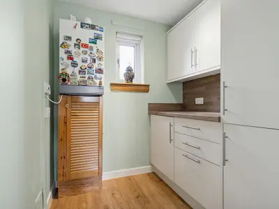 a kitchen with white cabinets and a refrigerator at Spacious 2 Bed in Falkirk in Falkirk