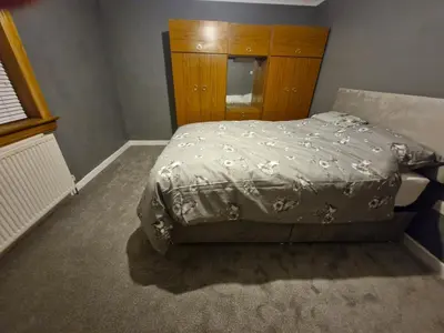 a bedroom with a bed and a wooden cabinet at Spacious 2 Bed in Falkirk in Falkirk