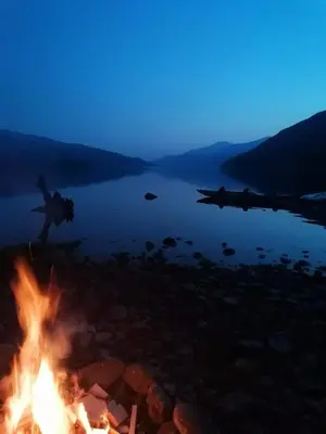 a campfire on the shore of a lake at night at Ardeonaig Lodge with Hot Tub & Water Fronted Games room in Ardeonaig