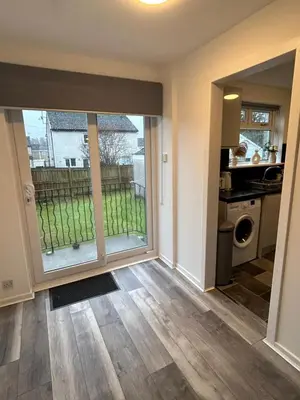 a living room with a large sliding glass door at 3BR Home Sleeps 10 with Private Drive Near Park in Newton Mearns