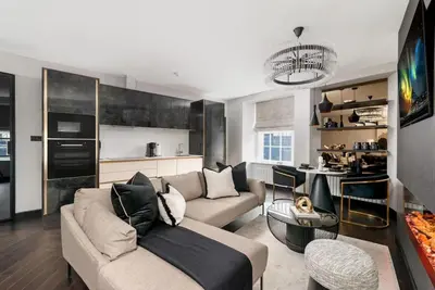 a living room with a couch and a kitchen at Near Transport - Hot tub - Fireplace - Sleeps 2 in Edinburgh