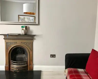 a living room with a fireplace and a mirror at Heart Of Edinburgh City Flat in Edinburgh