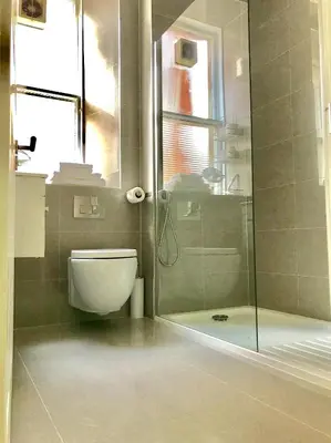 a bathroom with a toilet and a glass shower at Heart Of Edinburgh City Flat in Edinburgh