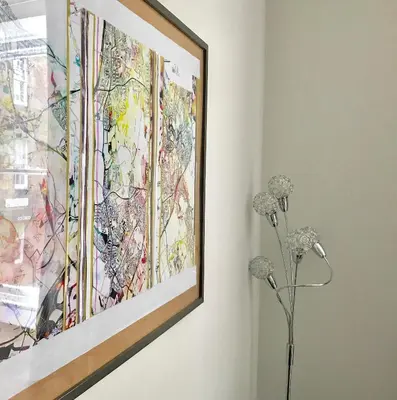 a painting hanging on a wall next to a vase with flowers at Heart Of Edinburgh City Flat in Edinburgh