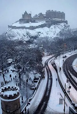 a snow covered city with a castle on a hill at Heart Of Edinburgh City Flat in Edinburgh