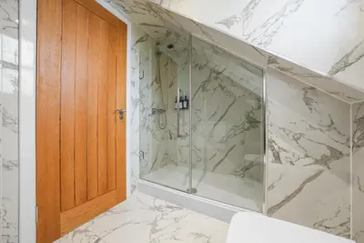 a bathroom with a shower with a glass door at The Penthouse - Beachwalk Apartments in Ayr