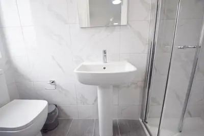 a white bathroom with a sink and a toilet at Cozy Golders Green Studio Flat in Moffat