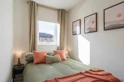 a bedroom with a bed with pillows and a window at Henderson House - West End 3 Bedroom Family Home in Glasgow