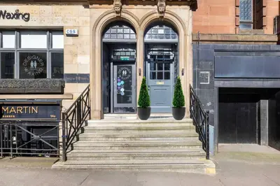 a entrance to a building with stairs and a blue door at The Sauchie in Glasgow